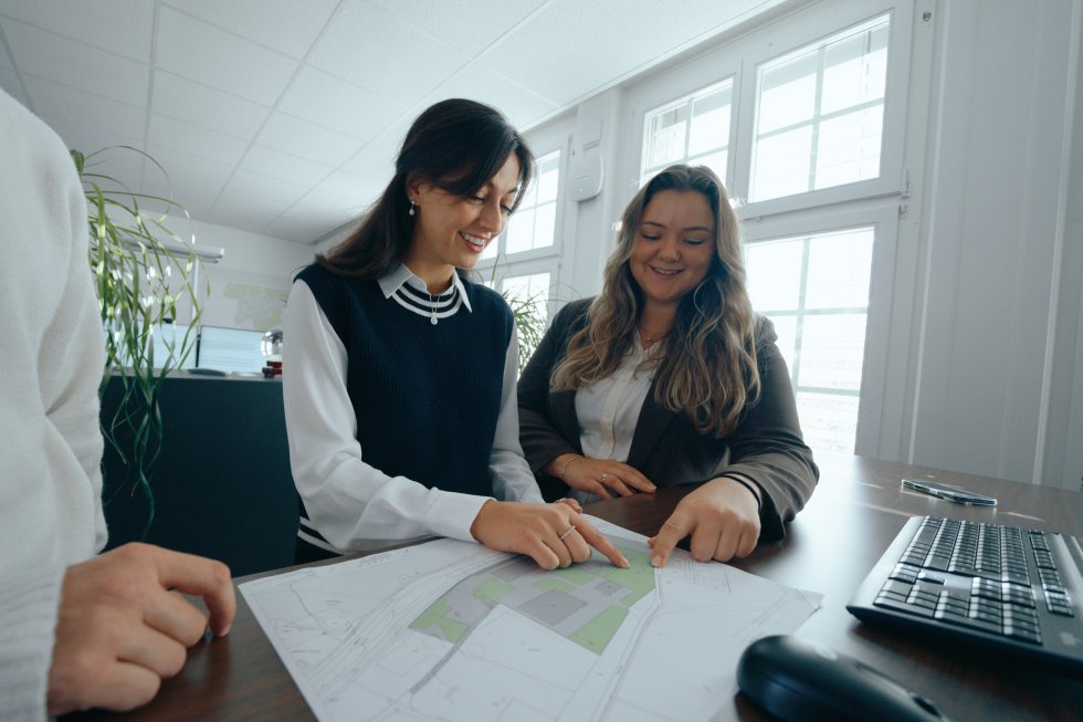 Zwei Frauen zeigen auf eine Karte