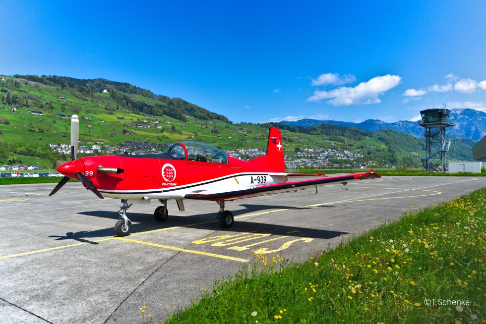 Ein rotes Fulgzeug steht auf einer Landebahn.